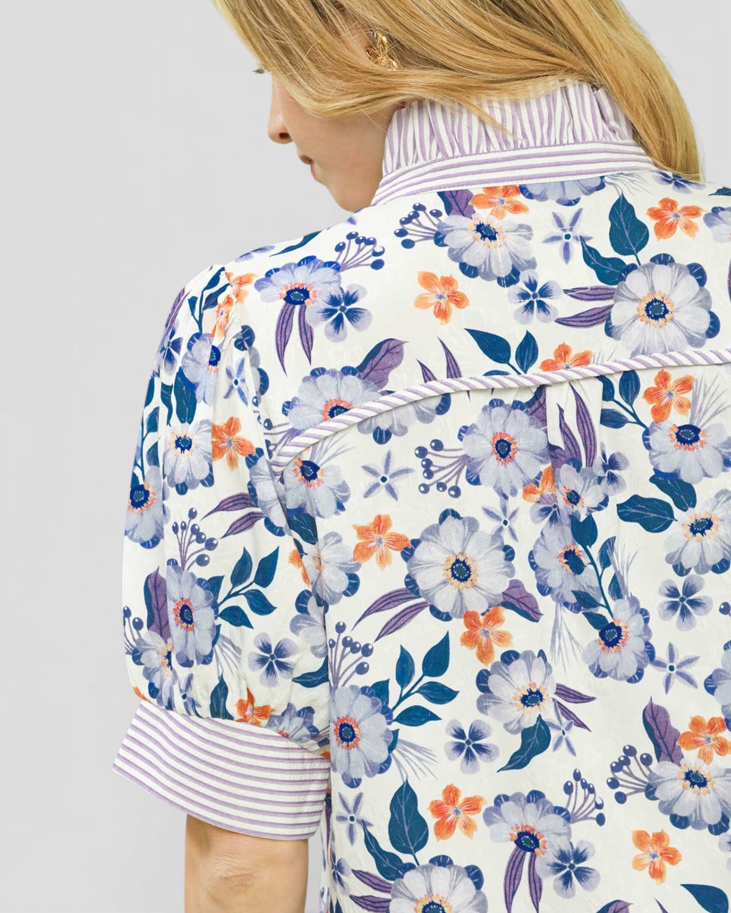 Person wearing a floral patterned jacket on a plain background