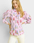 Woman wearing a pink floral blouse against a light background