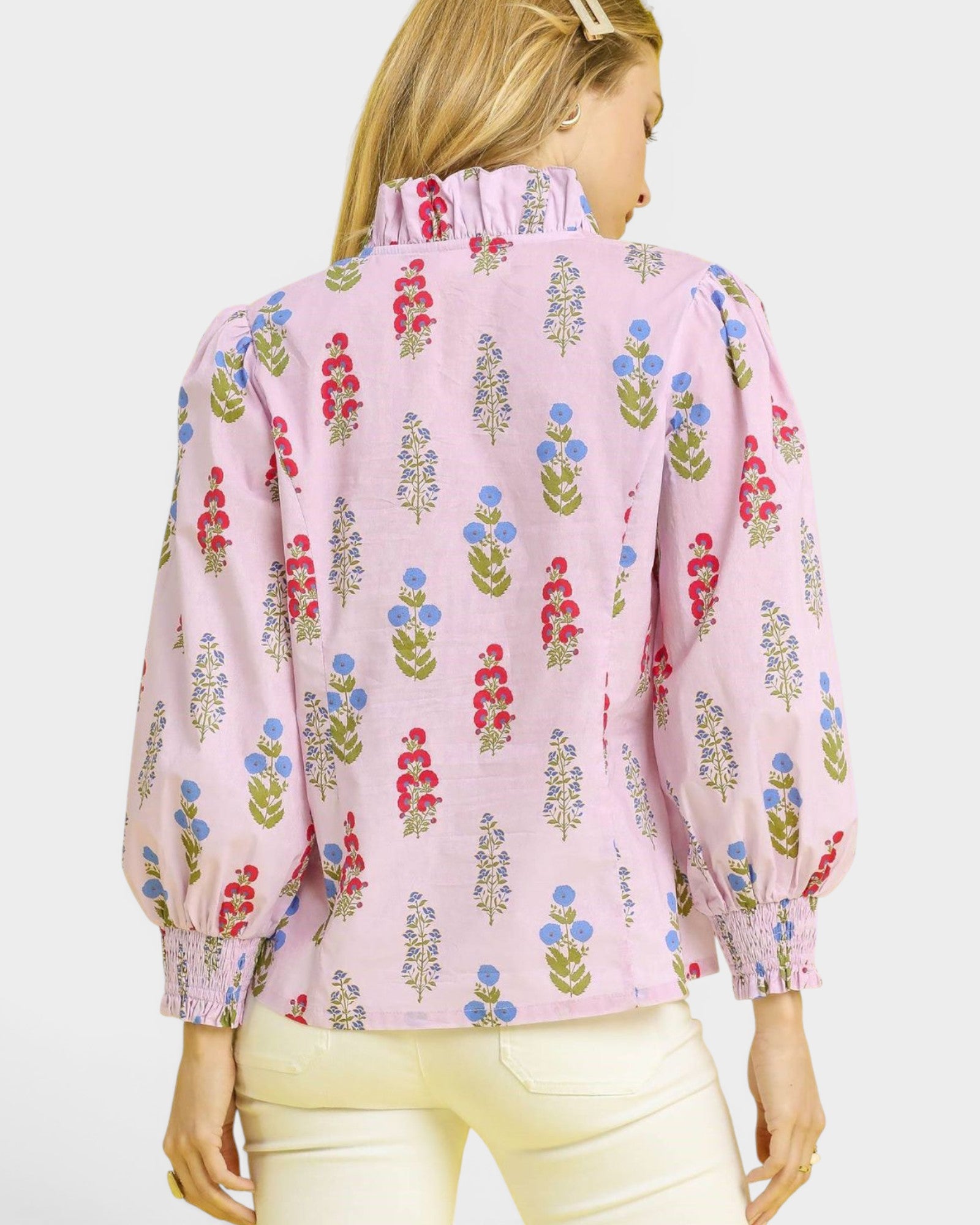 Woman wearing a pink floral blouse against a white background