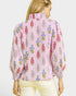 Woman wearing a pink floral blouse against a white background