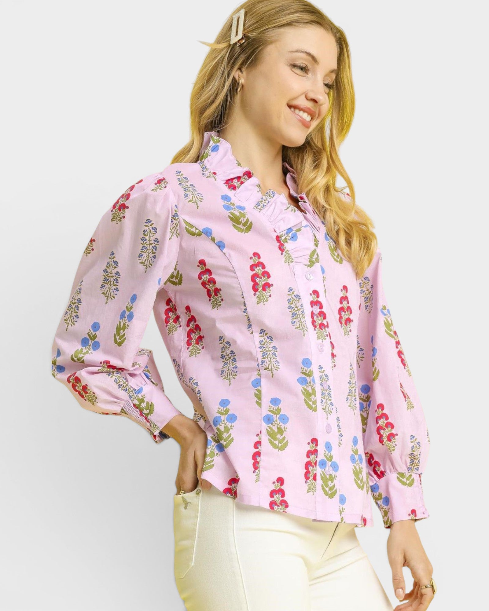 Woman wearing a pink floral blouse against a white background