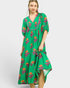 Woman wearing a green floral dress on a white background