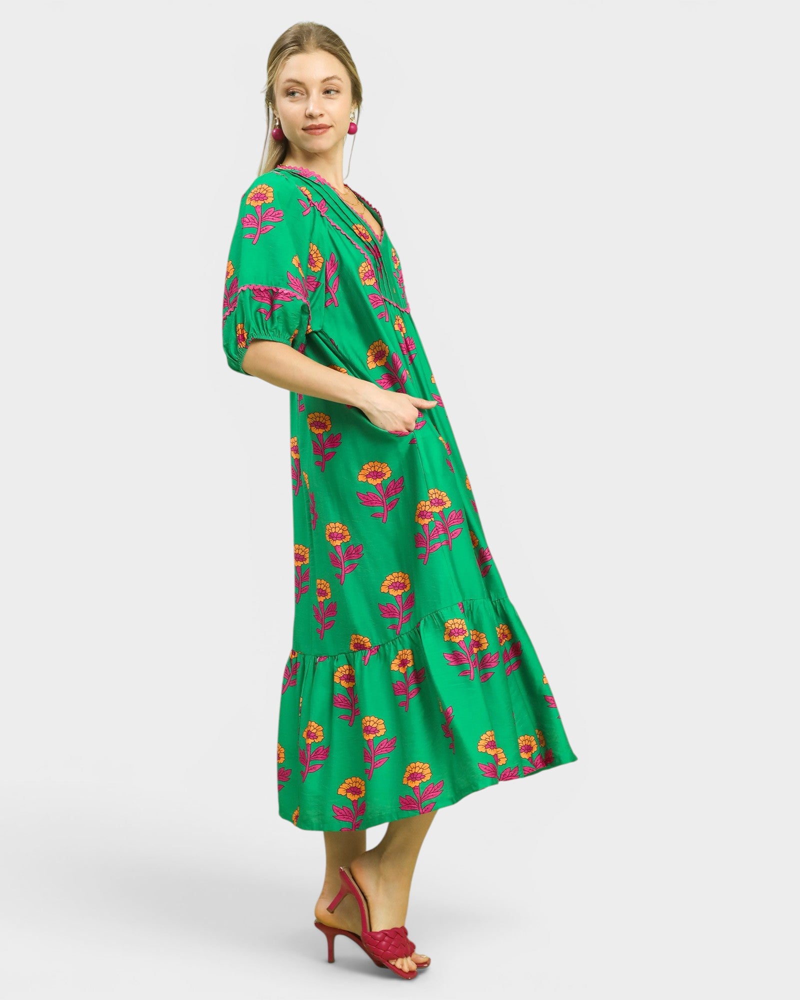 Woman wearing a green floral dress on a white background
