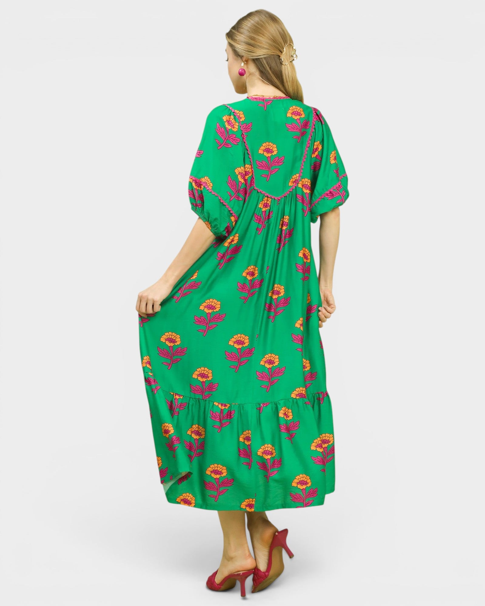 Woman wearing a green dress with floral patterns on a white background