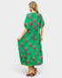 Woman wearing a green dress with floral patterns on a white background