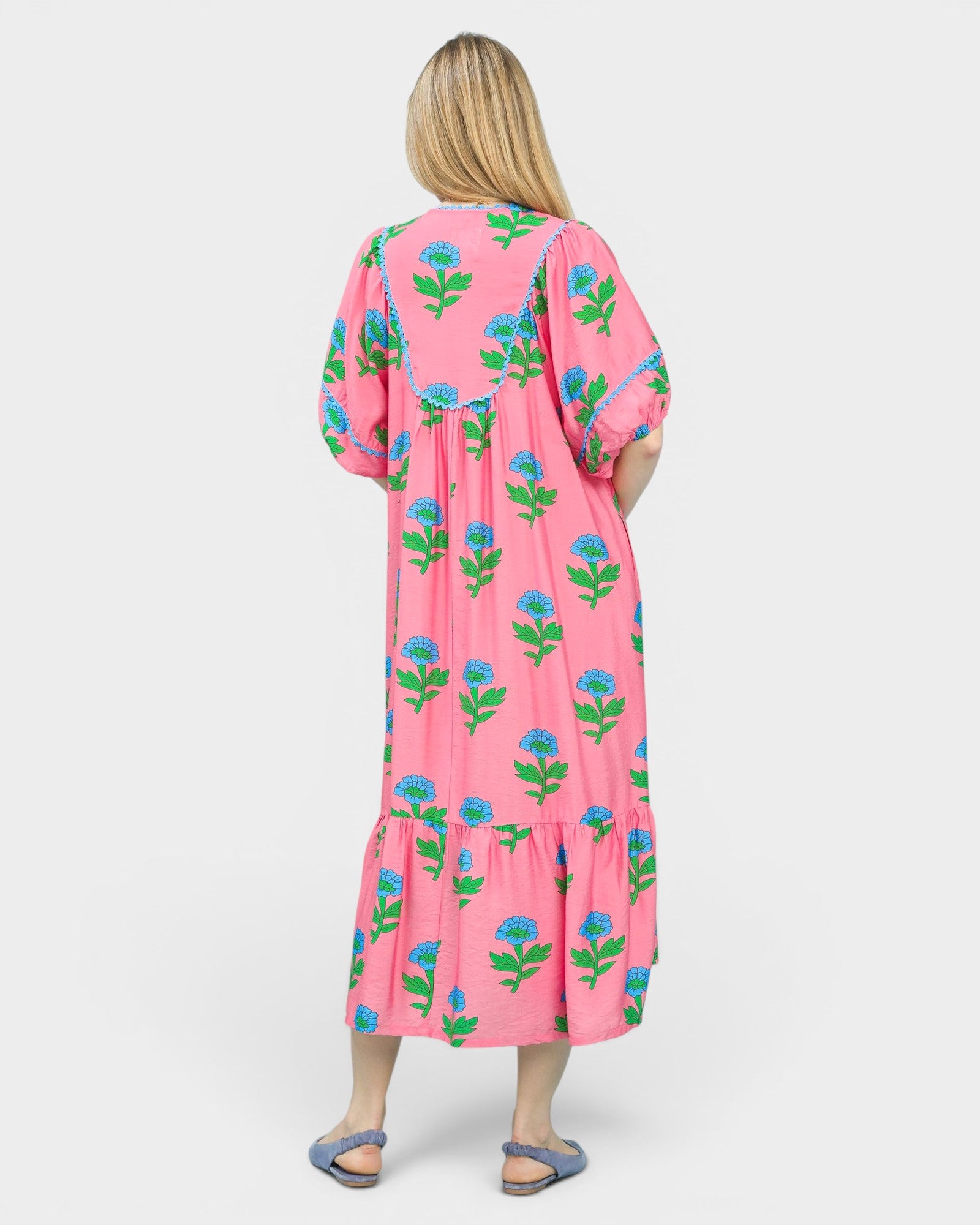 Woman wearing a pink floral dress on a white background