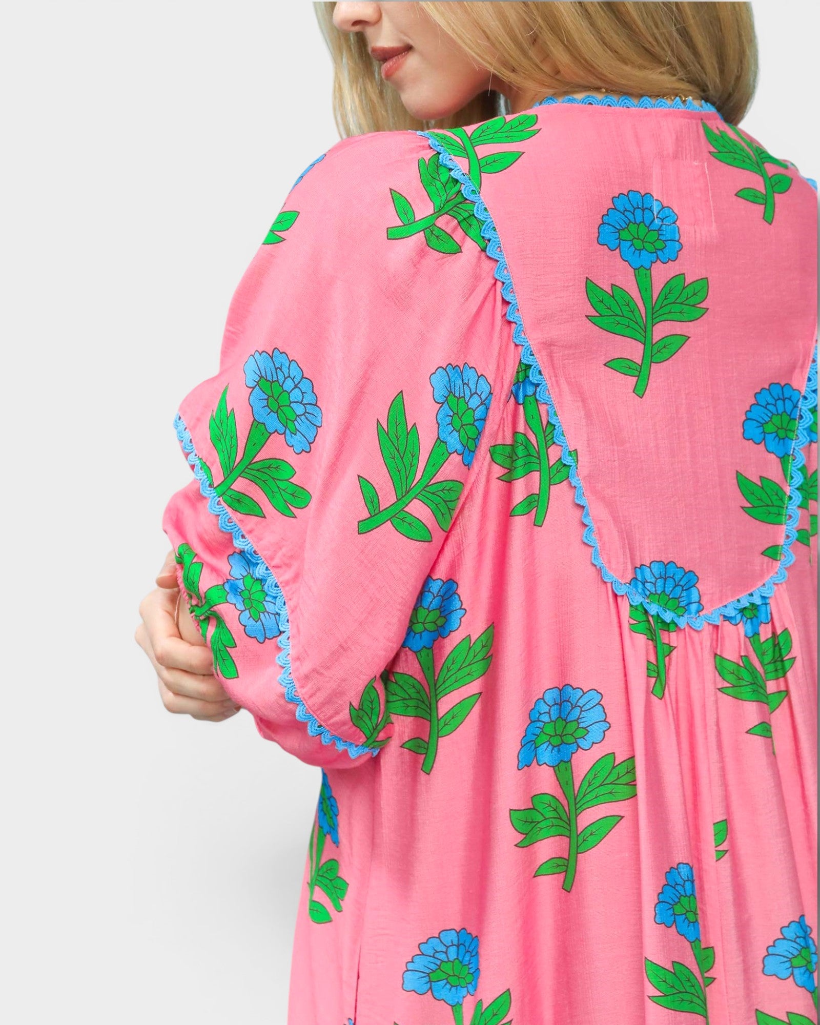 Pink garment with blue and green floral patterns on a plain background