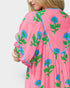 Pink garment with blue and green floral patterns on a plain background