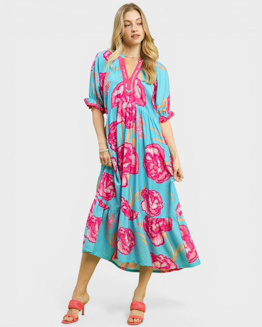 Woman wearing a floral dress with pink flowers on a white background