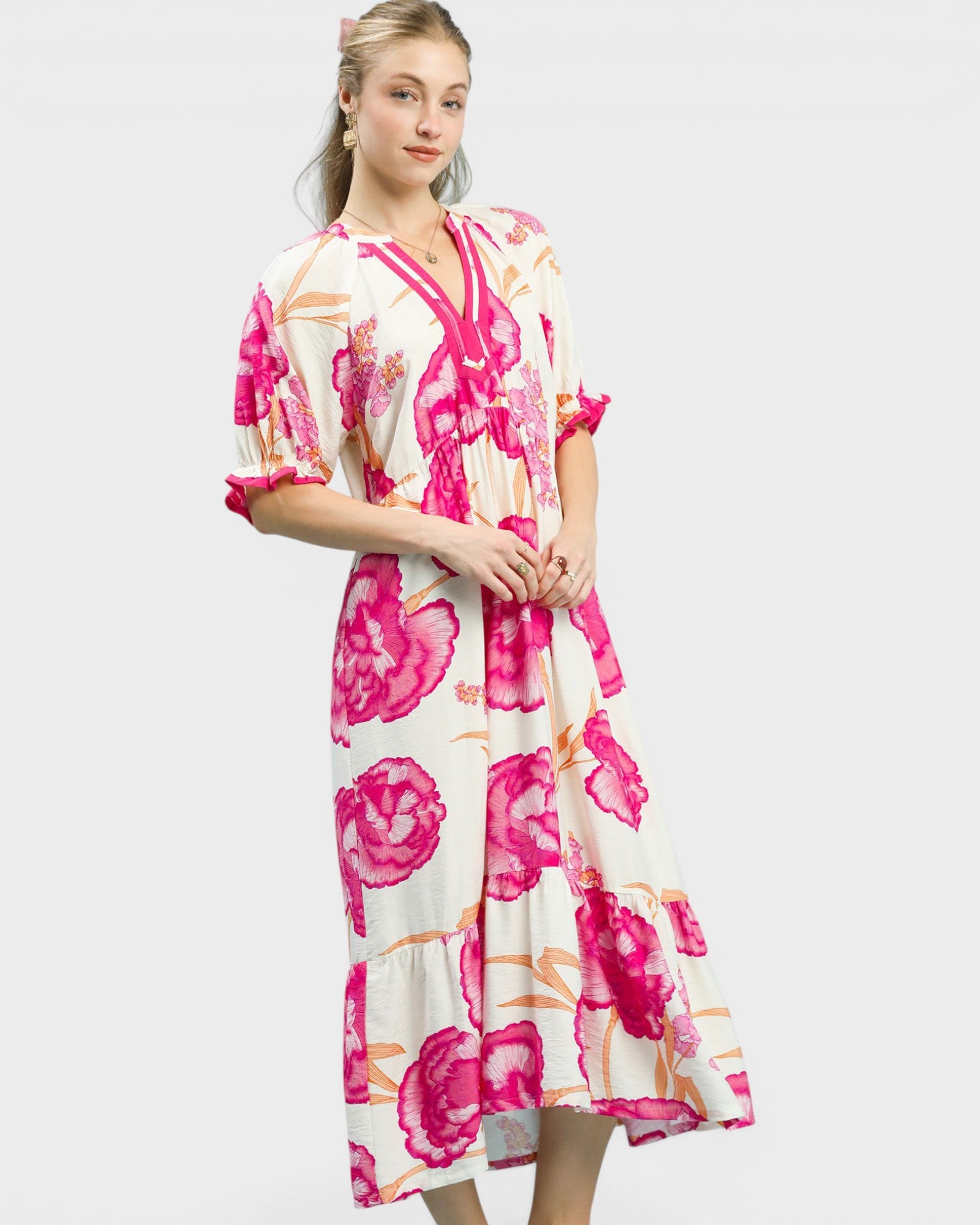 Woman wearing a floral dress with pink flowers on a white background