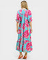 Woman wearing a floral dress with pink flowers on a light blue background