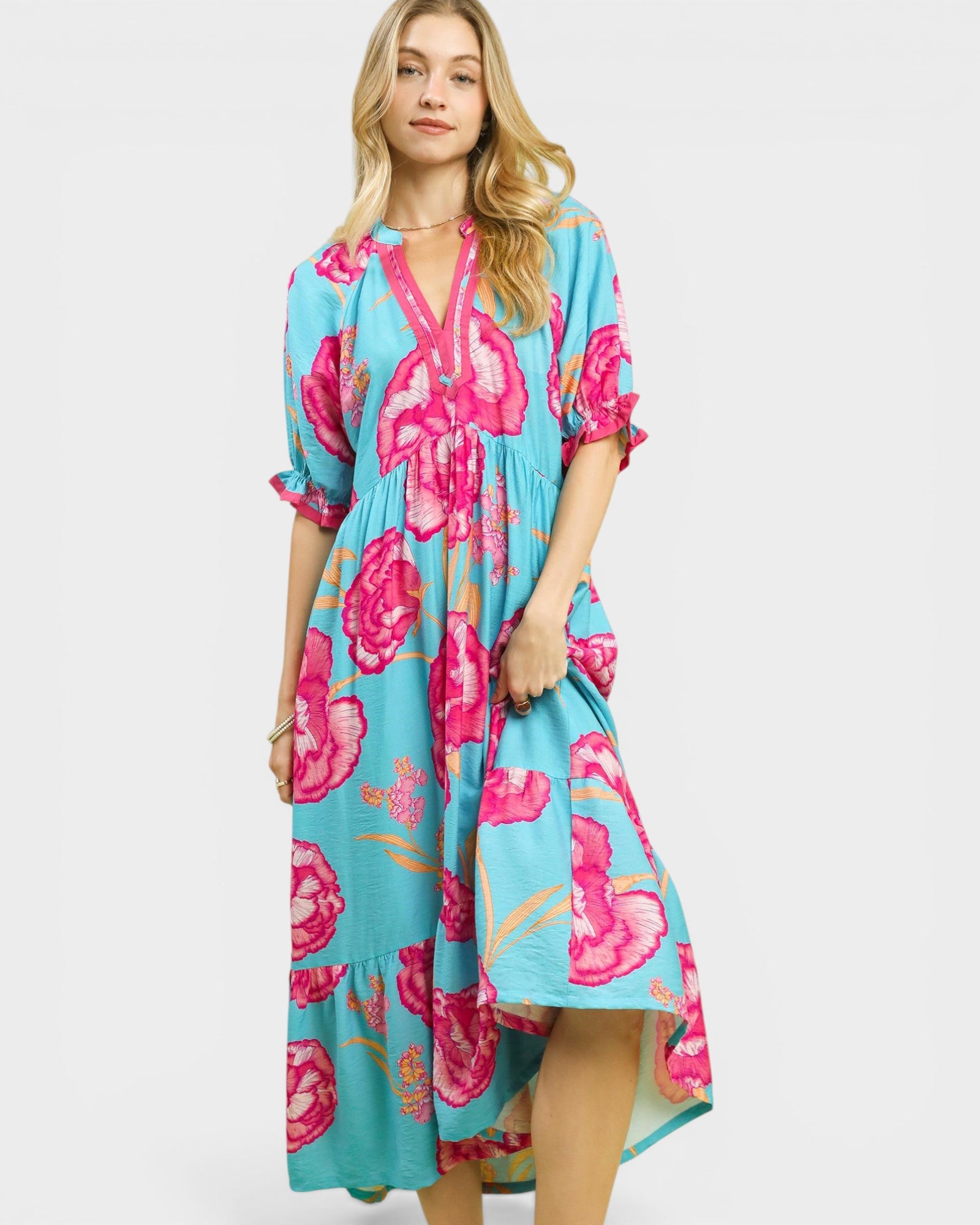 Woman wearing a blue floral dress with pink flowers on a white background