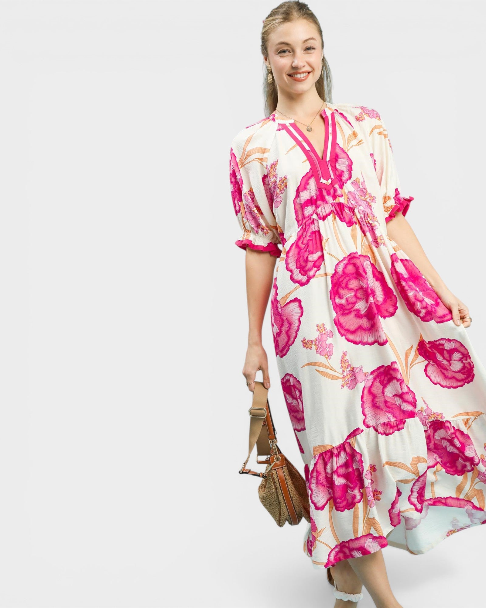 Woman wearing a floral dress with pink flowers on a white background