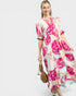 Woman wearing a floral dress with pink flowers on a white background