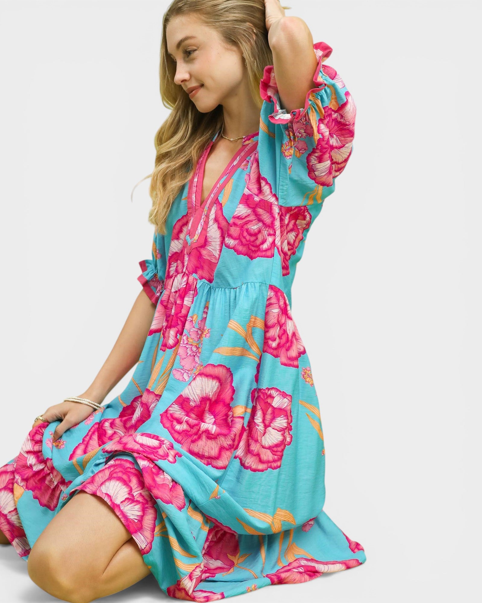 Woman wearing a floral dress with pink and blue colors on a white background