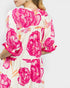 Woman wearing a dress with pink floral pattern on a white background