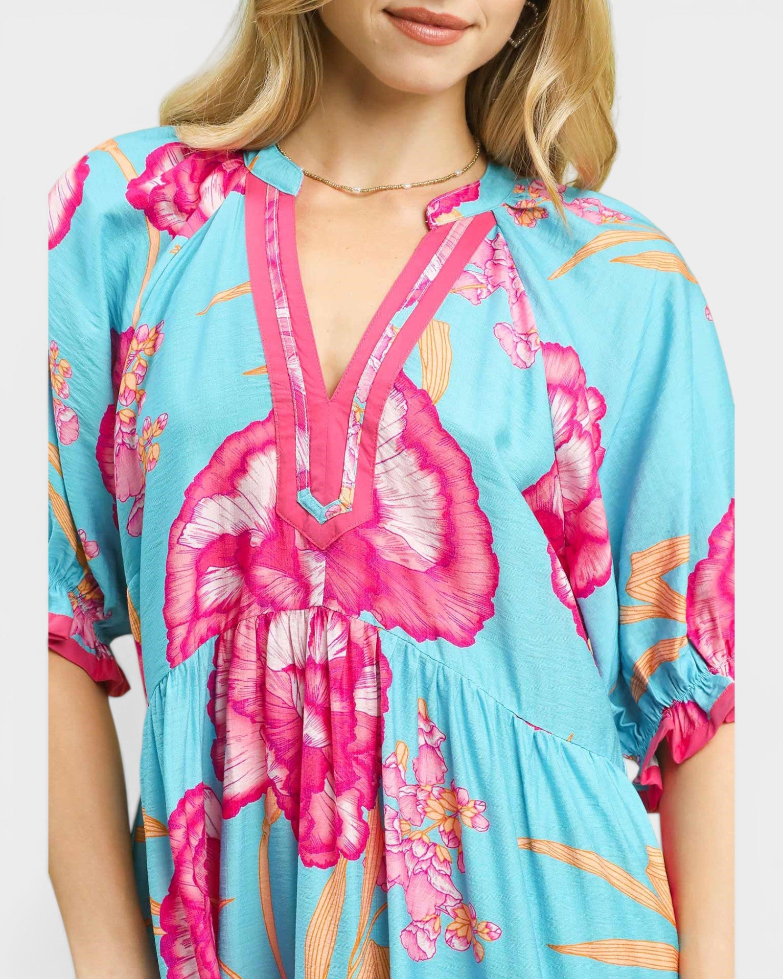 Woman wearing a colorful floral dress with a blue background