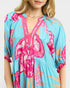 Woman wearing a colorful floral dress with a blue background