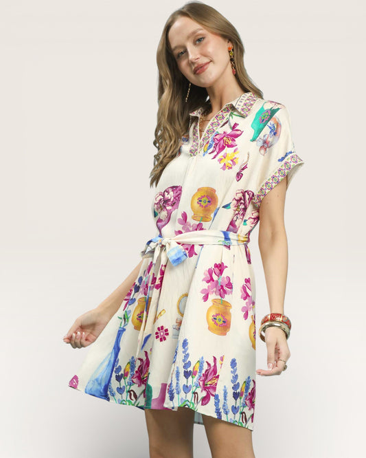 Woman wearing a colorful floral dress on a plain background