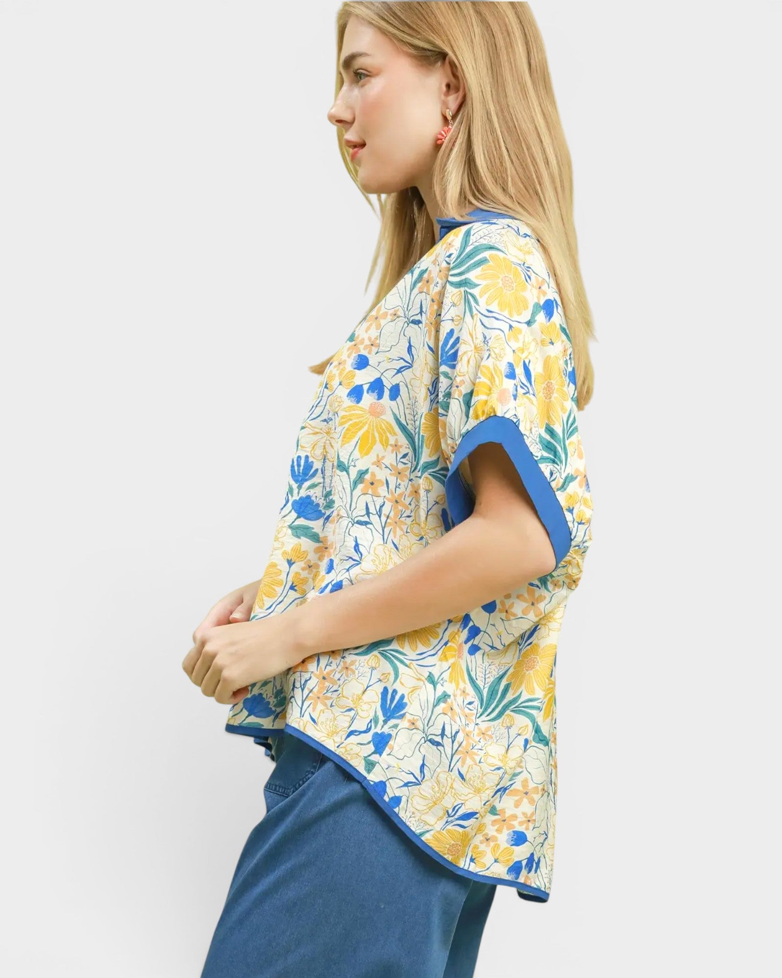 Woman wearing a floral blouse with blue accents on a white background