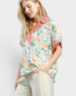 Woman wearing a floral blouse with a plain background