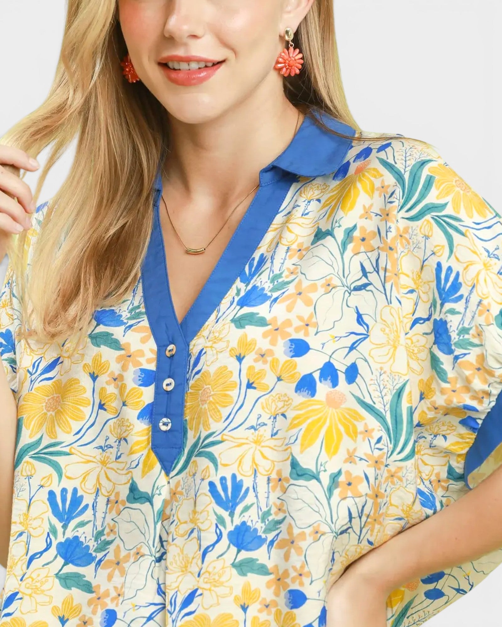 Woman wearing a floral blouse with blue collar on a white background