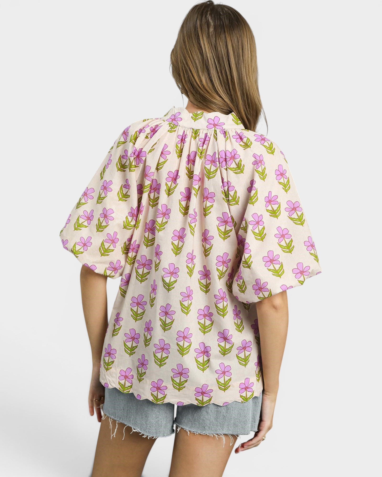 Woman wearing a floral blouse with a plain background
