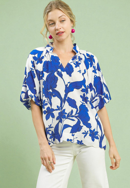 Woman wearing a blue and white floral blouse against a green background