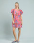 Woman wearing a pink floral dress on a gray background
