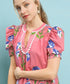 Woman wearing a pink floral dress with a blue background