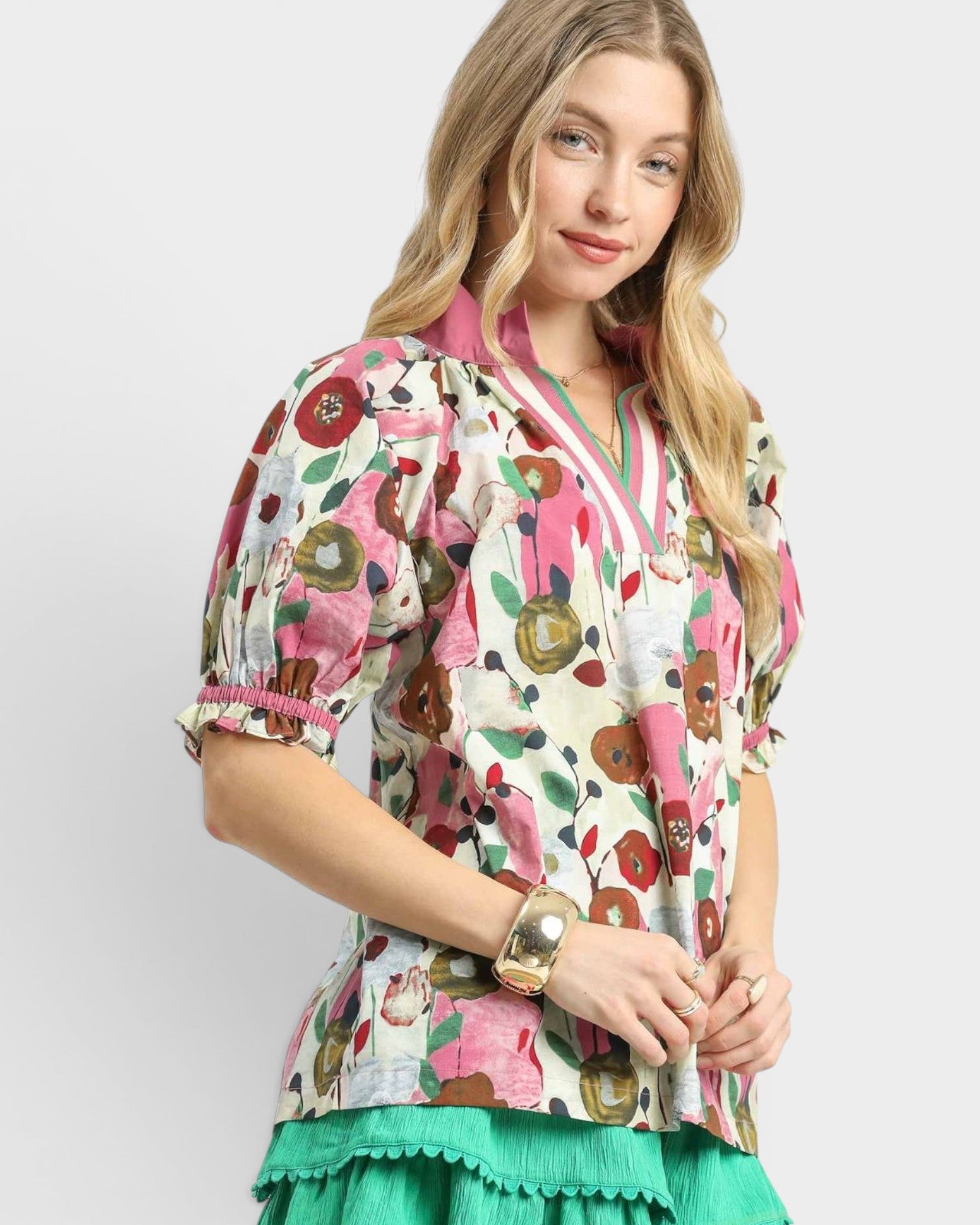 Woman wearing a colorful floral blouse with a plain background