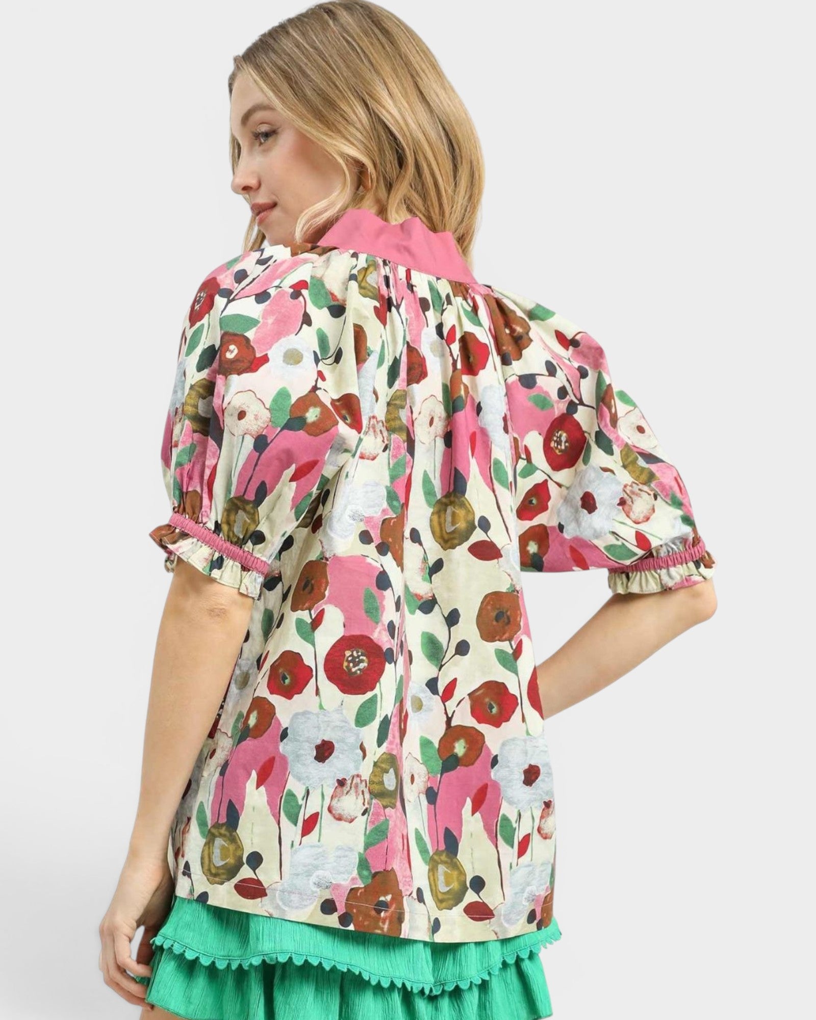 Woman wearing a colorful floral blouse with a white background