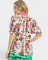 Woman wearing a colorful floral blouse with a white background