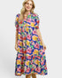Woman wearing a colorful floral dress on a white background