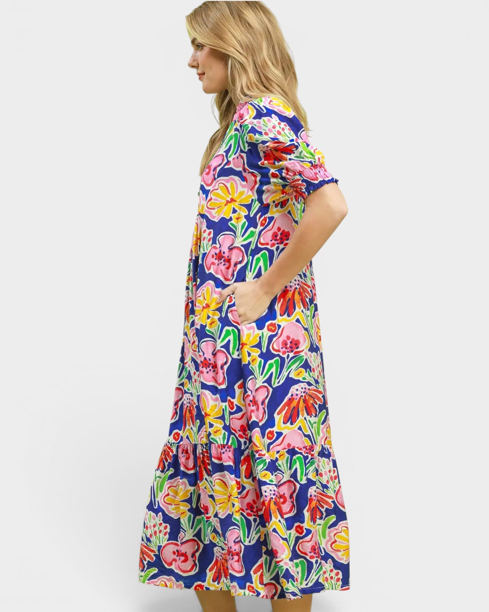 Woman wearing a colorful floral dress on a white background