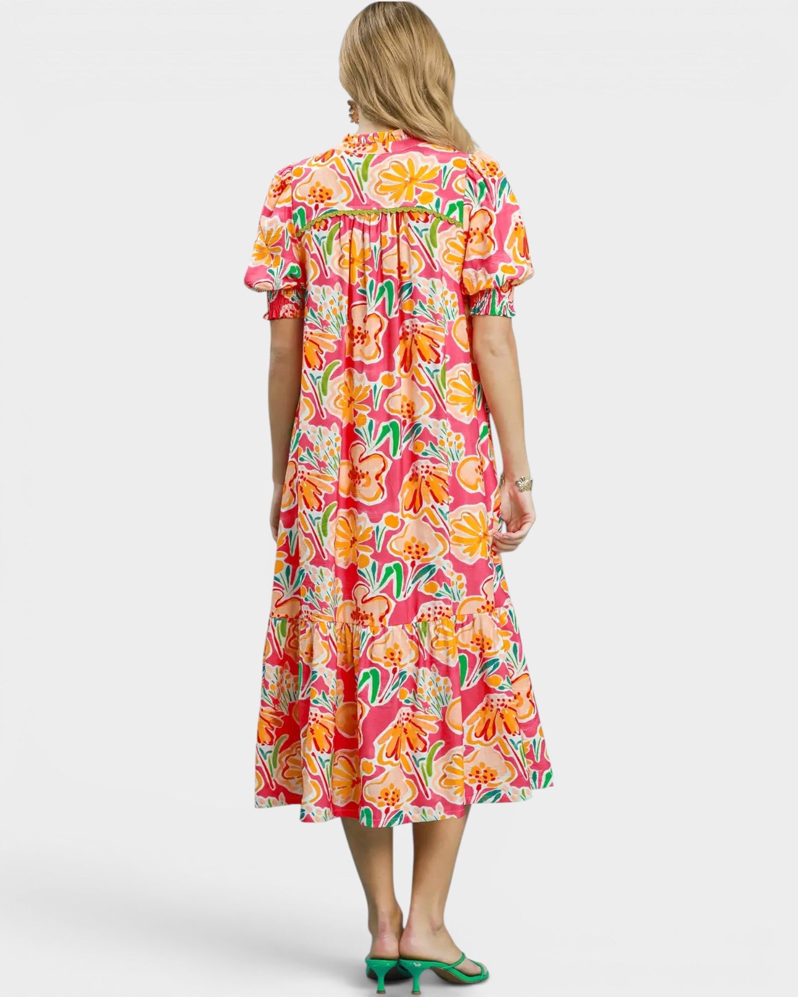 Woman wearing a colorful floral dress on a white background