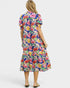 Woman wearing a colorful floral dress on a white background