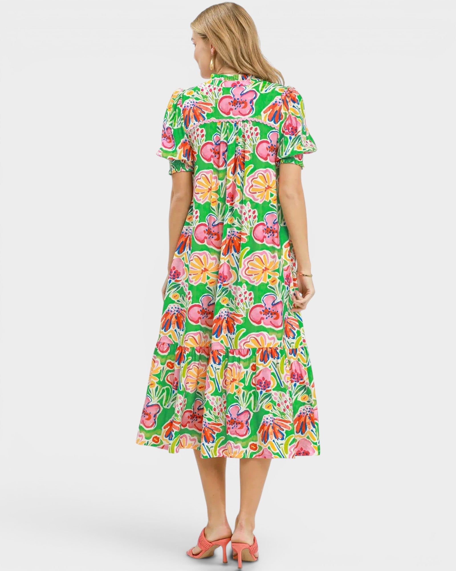 Woman wearing a colorful floral dress on a white background