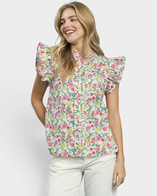 Woman wearing a floral blouse with ruffled sleeves on a white background