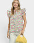 Woman wearing a floral blouse holding a yellow bag against a white background