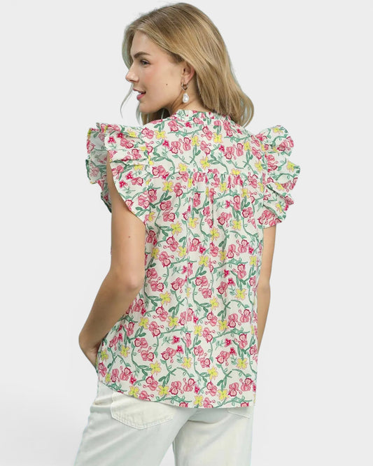 Woman wearing a floral blouse with ruffled sleeves on a white background