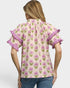 Woman wearing a floral blouse with ruffled sleeves on a plain background