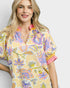Woman wearing a colorful floral dress with a plain background