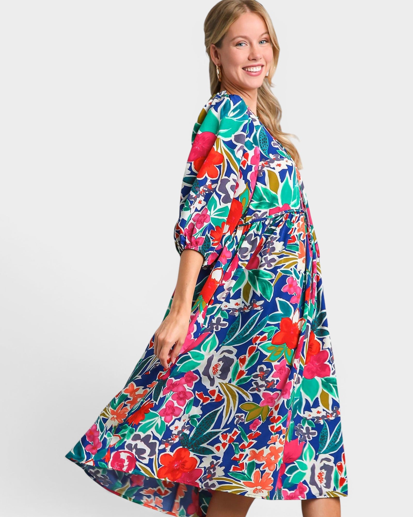 Woman wearing a colorful floral dress on a white background