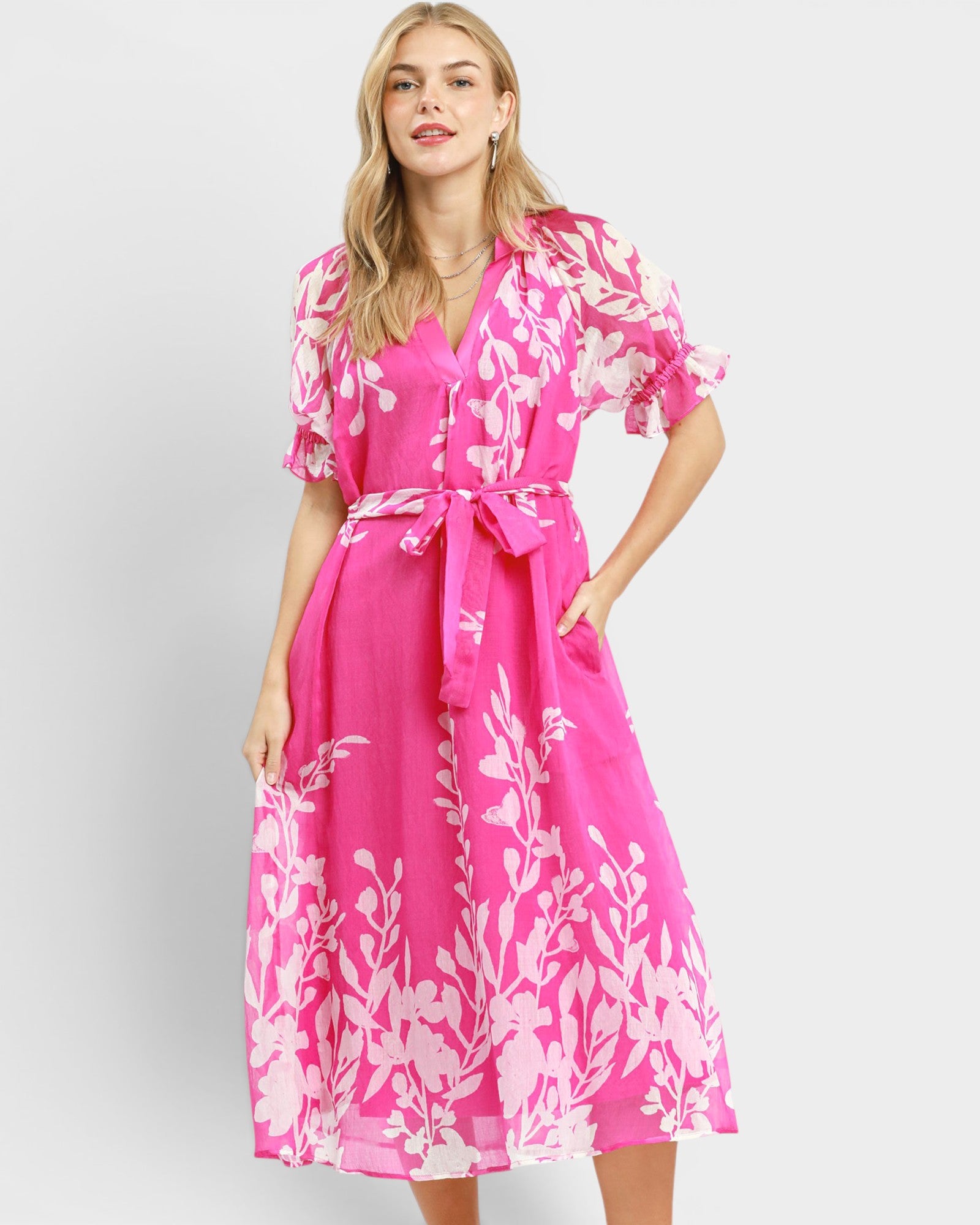 Woman wearing a pink floral dress on a white background