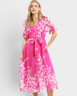 Woman wearing a pink floral dress on a white background