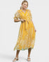 Woman wearing a yellow floral dress on a white background