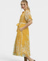 Woman wearing a yellow floral dress on a white background