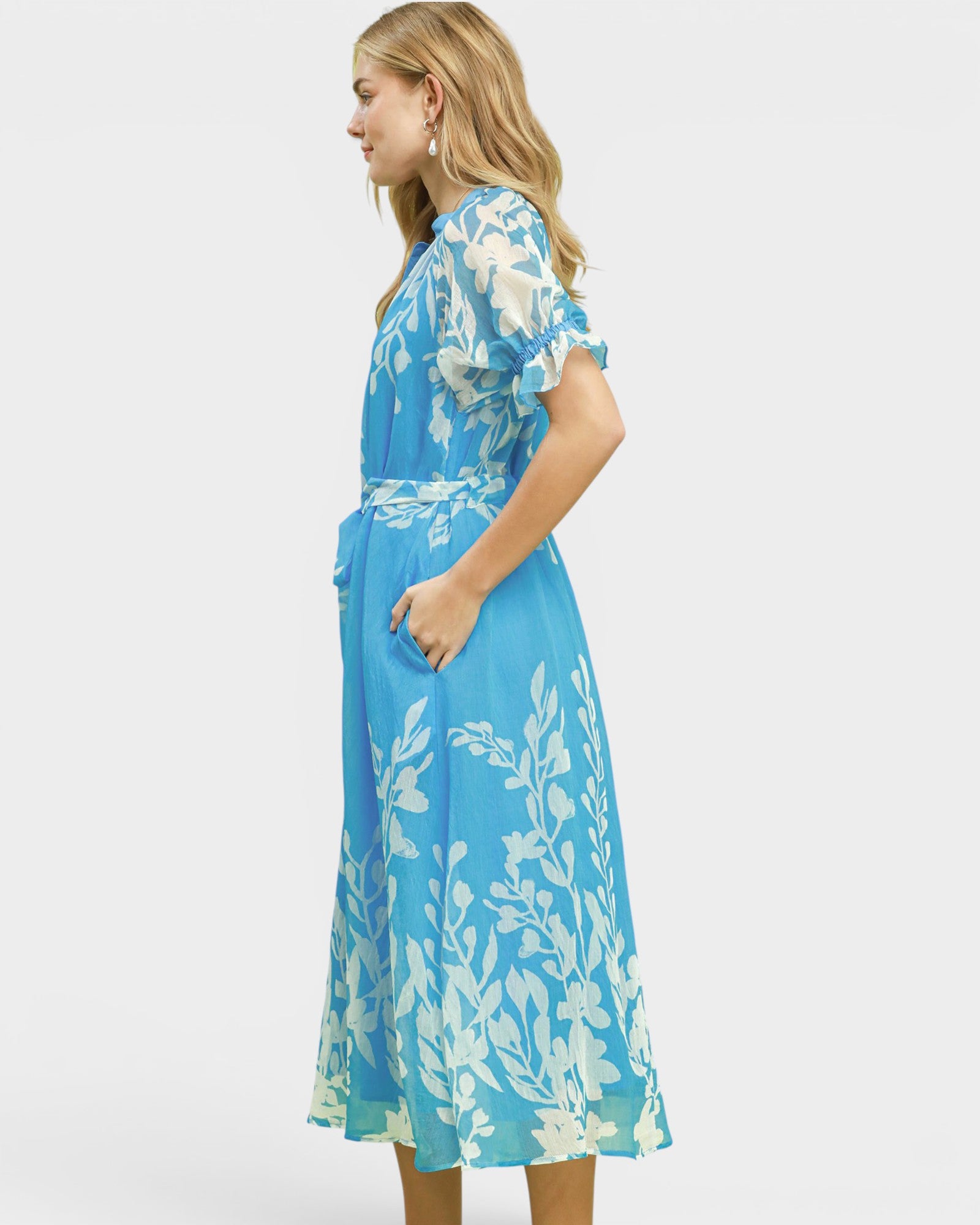 Woman wearing a blue floral dress on a white background