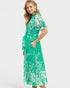 Woman wearing a green floral dress on a white background